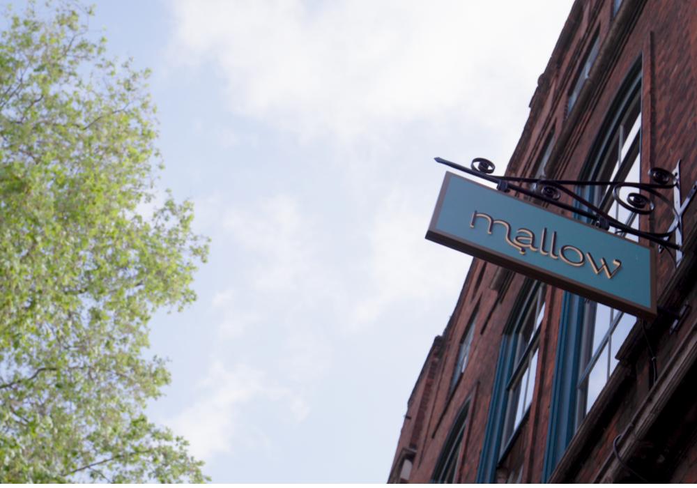 A restaurant with a sign that says Mallow hanging outside the restaurant