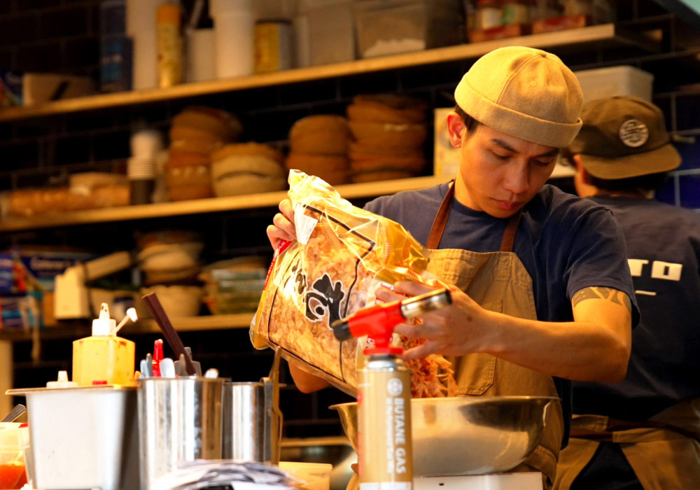 Chef pouring ingredients in bowl in a Japanese restaurant