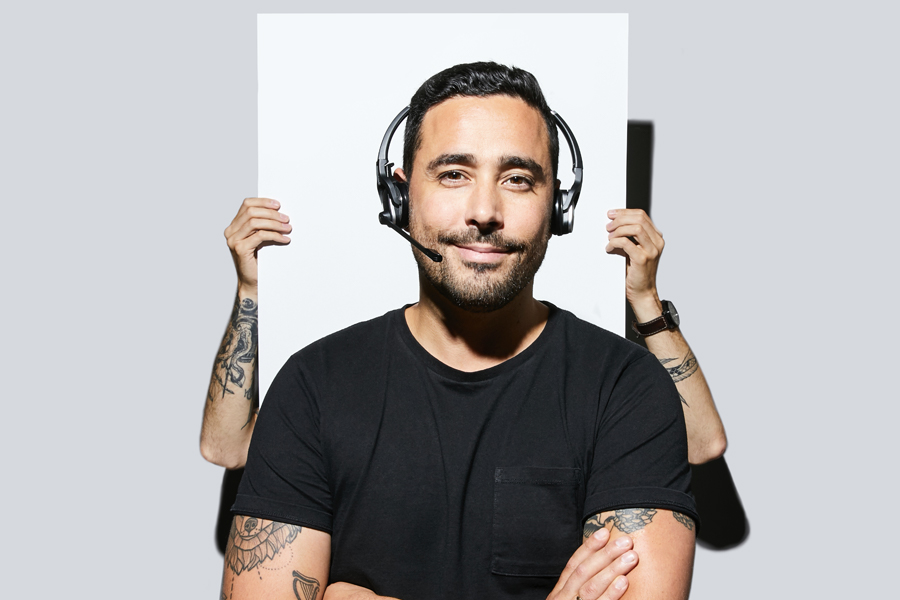 Support specialist smiling with his headphones on