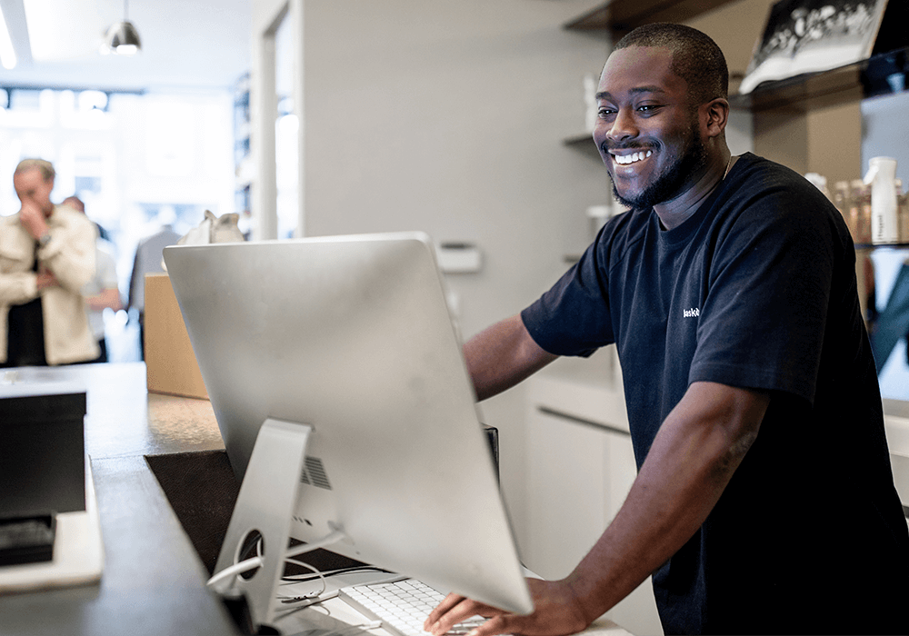 Person using ePOS on desktop, smiling