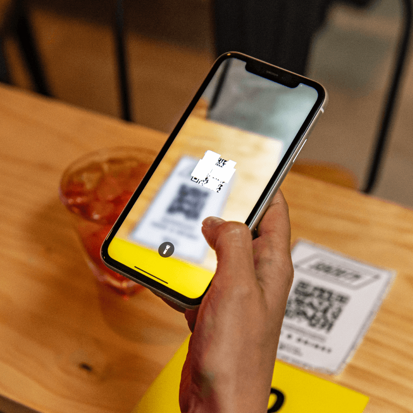 Person scanning restaurant menu from their Iphone using a QR code