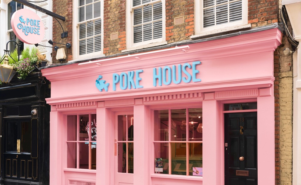 A pink building with the words Poke House in blue letters