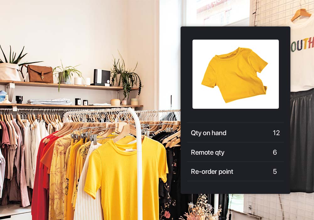 Picture of T-shirt with quantity on hand, remote quantity and reorder point listed below it. Clothes hanging in a clothing store in the background.