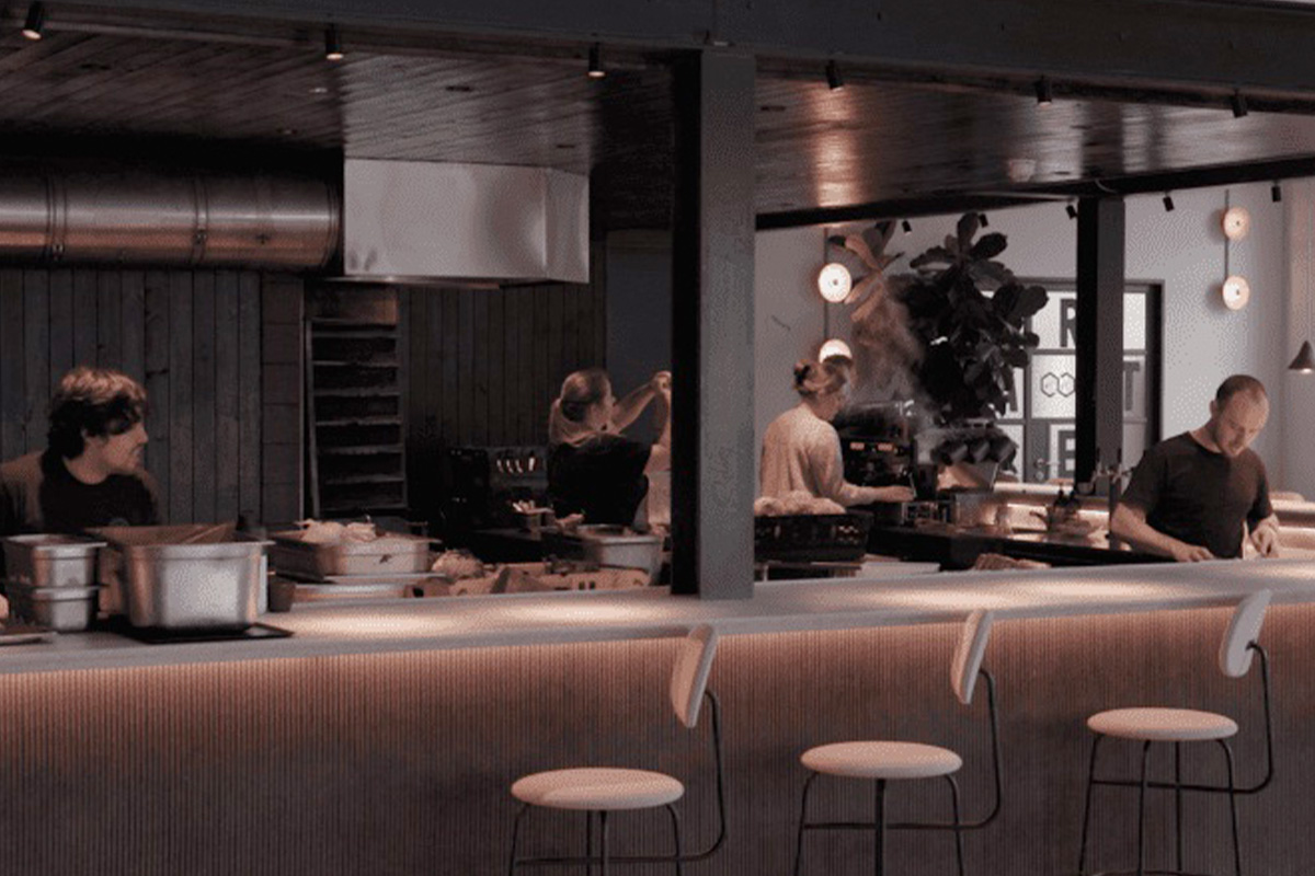 An open plan kitchen with four people working in the kitchen