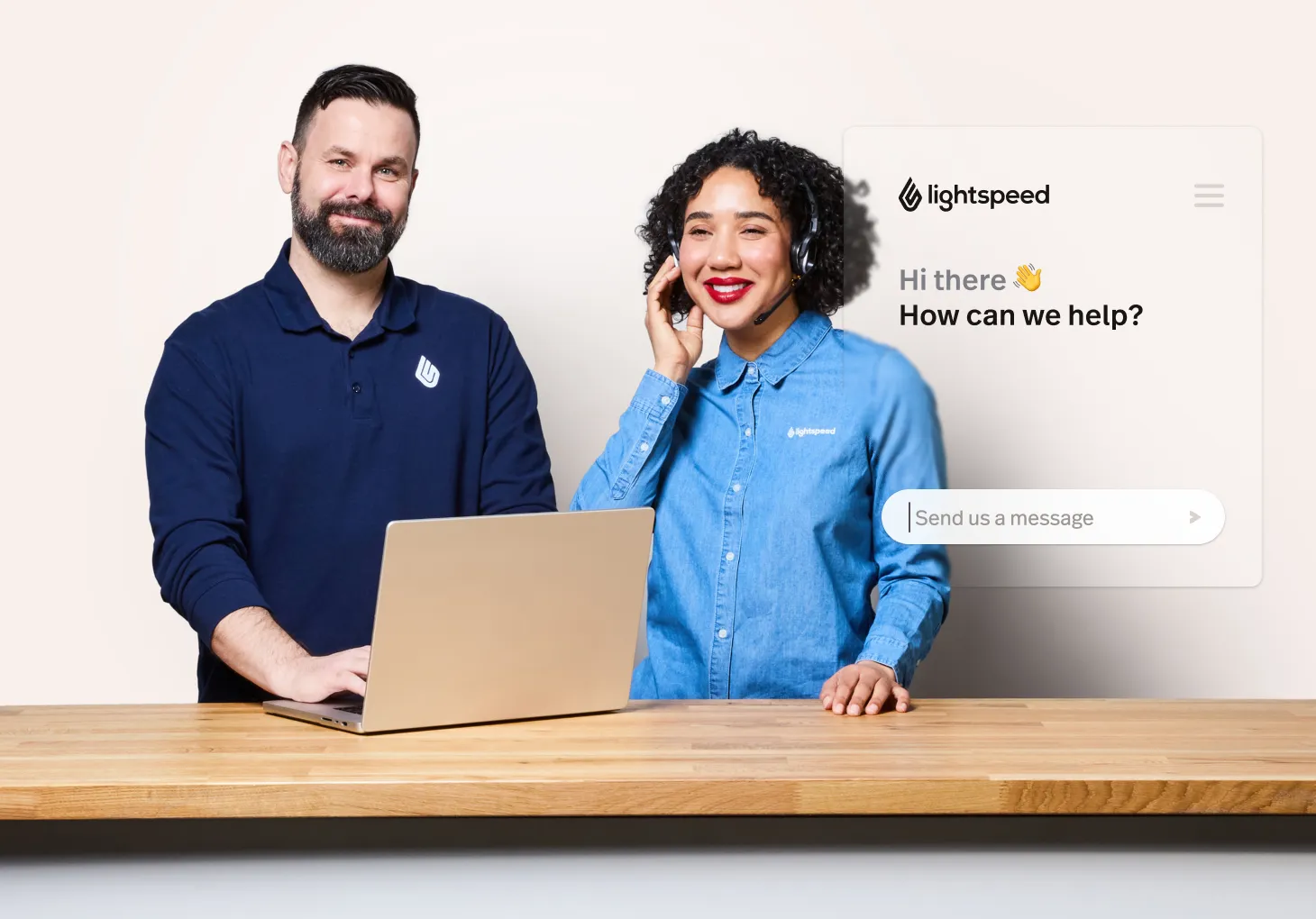 Two customer support workers stand at a counter. One is on the phone.
