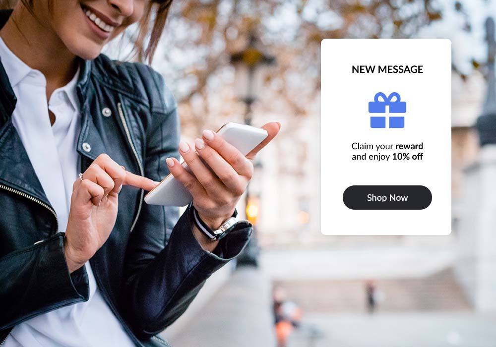 Person looking at their phone, smiling after recieving a new message from Lightspeed Loyalty