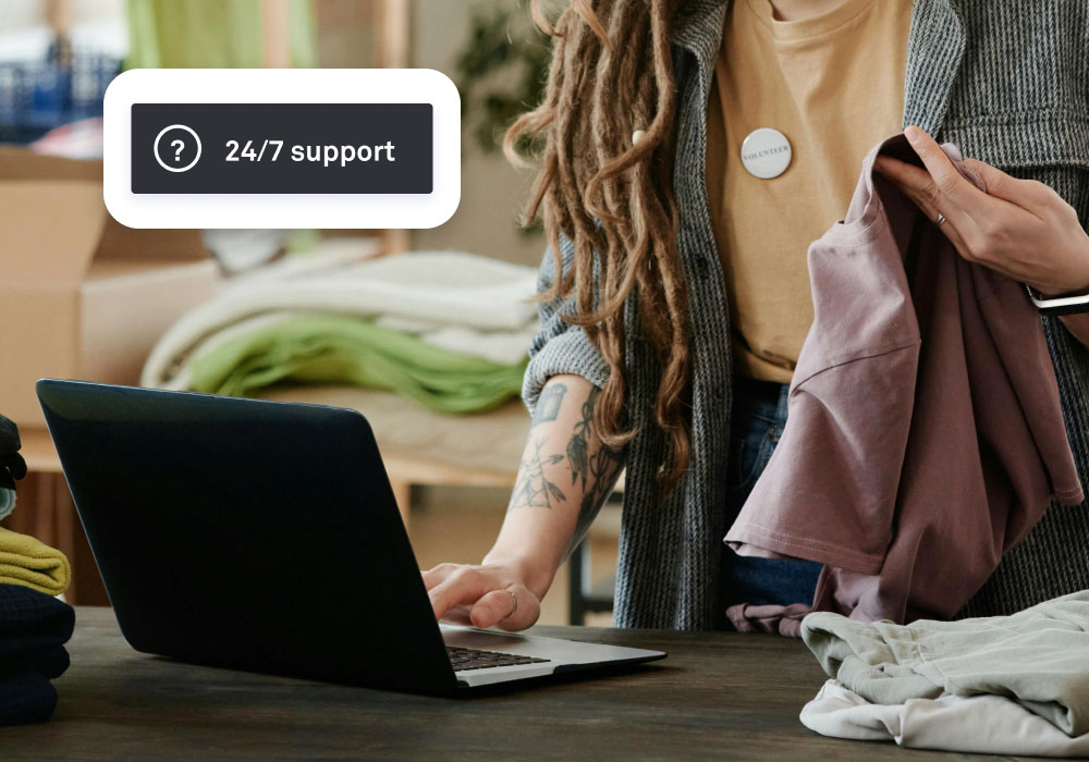 A woman uses a computer with Lightspeed's non profit POS software on it, with a floating module that shows 24/7 support
