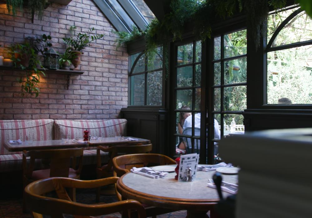 A restaurant with exposed brick walls looking out to a garden