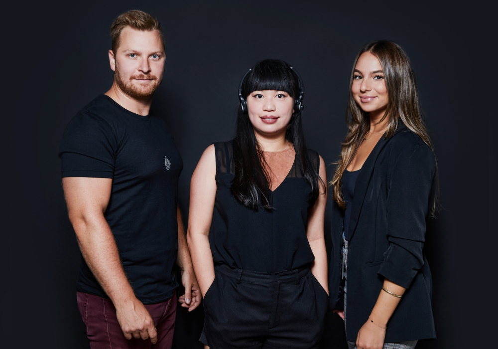 Three people wearing black clothing all looking at the camera and smiling