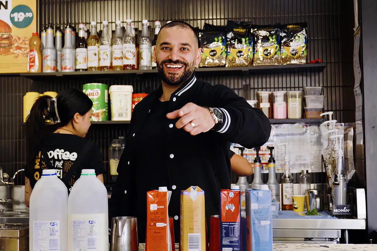 A man laughs behind the counter at a bar.