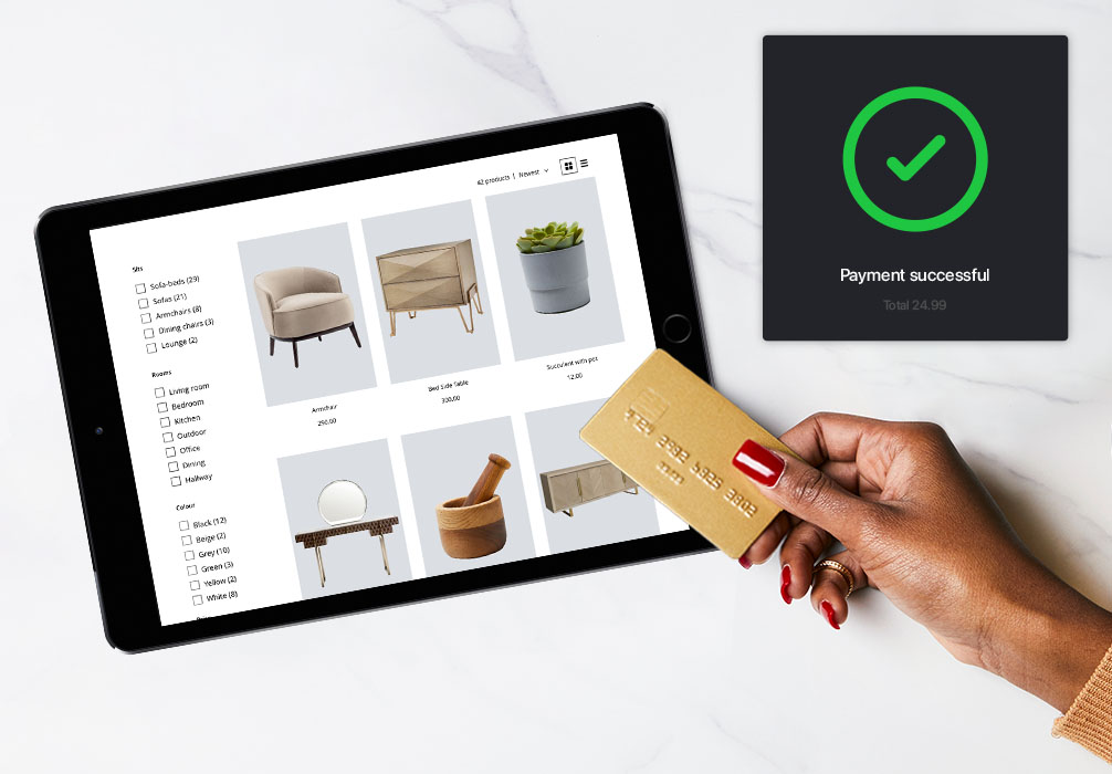 iPad screen showing an eCommerce product page, next to it a hand holds a credit card. A green trick in the top right signifies a successful online payment.