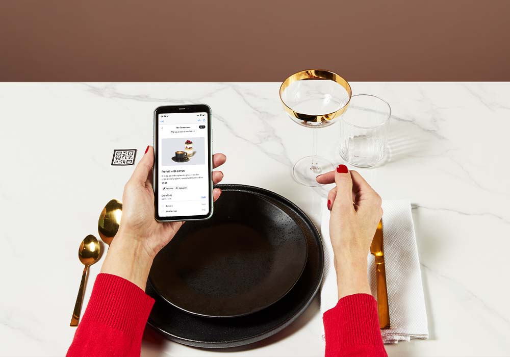hands using a smart phone on a restaurant table