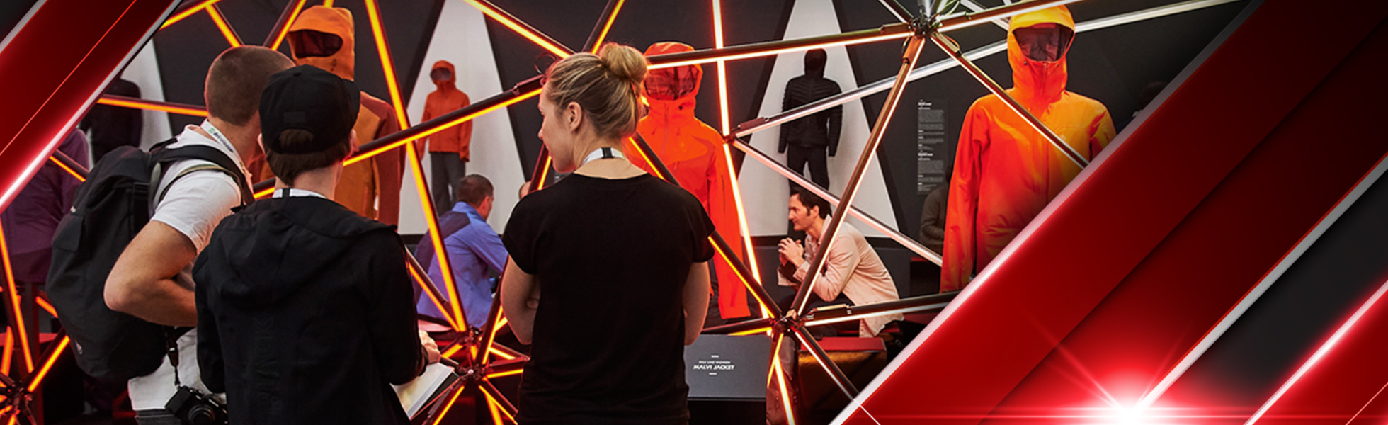Three people attend a showing of cold weather sporting goods wear.