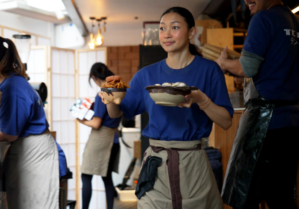 Waitress serving japanese food on handmade pottery plates