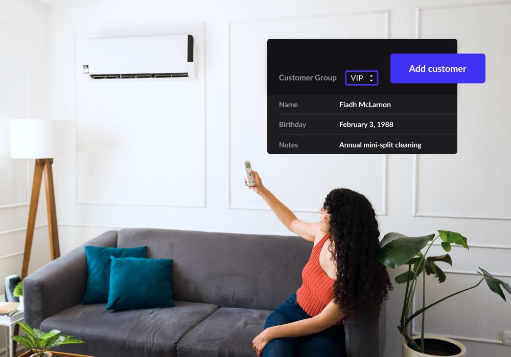 Person using a remote to control HVAC while sitting on a couch.